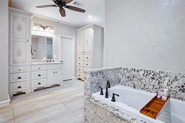 a bathroom with a bathtub a sink and a mirror