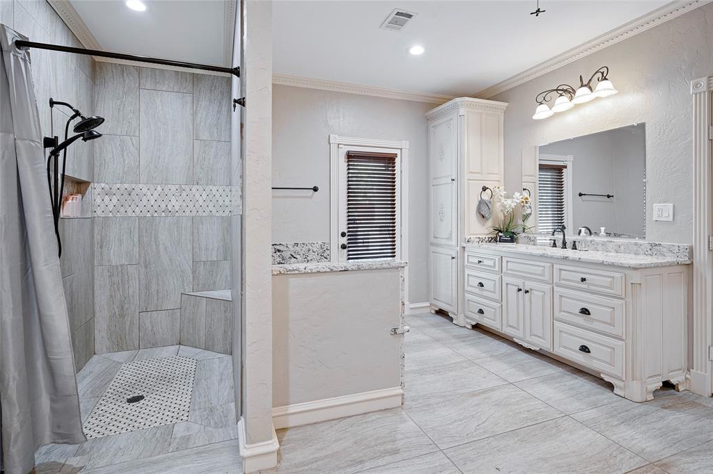 2309 Parker Road St. Paul, TX 75098 - Photo 20 of 40 a bathroom with a granite countertop sink a mirror a shower and a bathtub