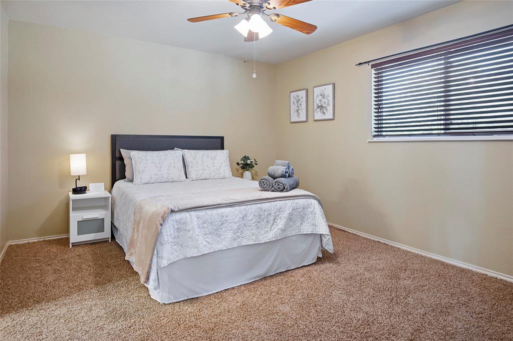 2309 Parker Road St. Paul, TX 75098 - Photo 29 of 40 a bedroom with a bed and a chandelier