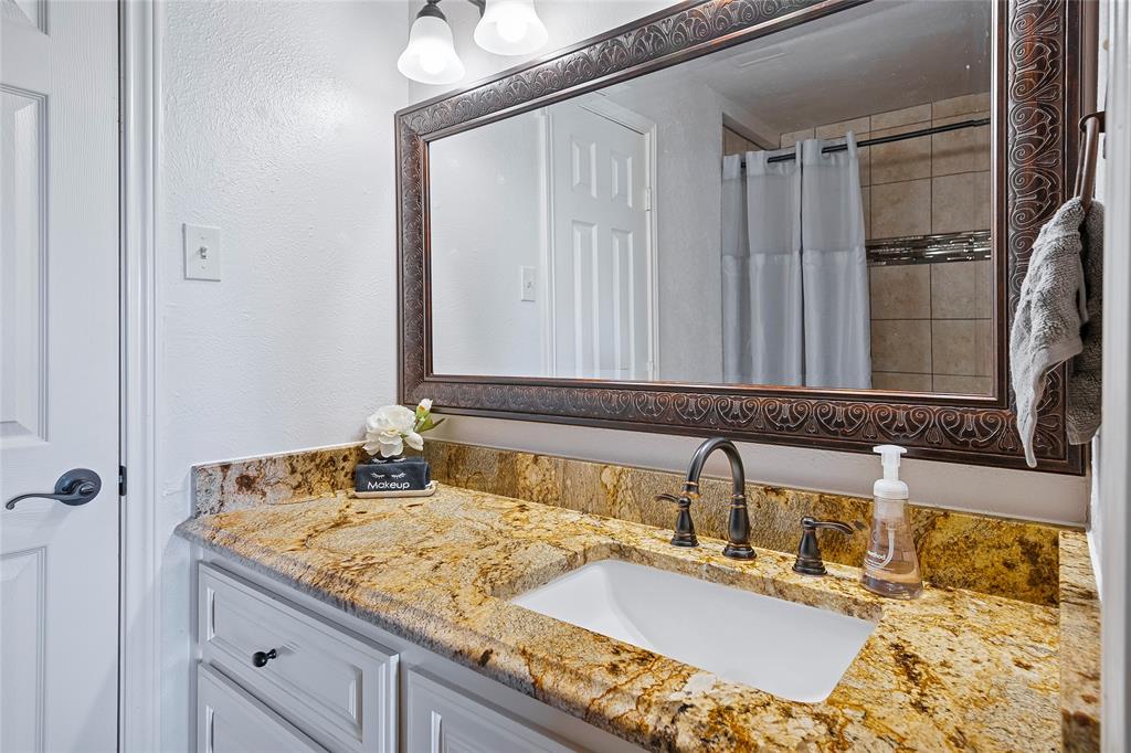 2309 Parker Road St. Paul, TX 75098 - Photo 32 of 40 a bathroom with a granite countertop sink and a mirror