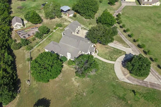 an aerial view of a house with a yard and greenery