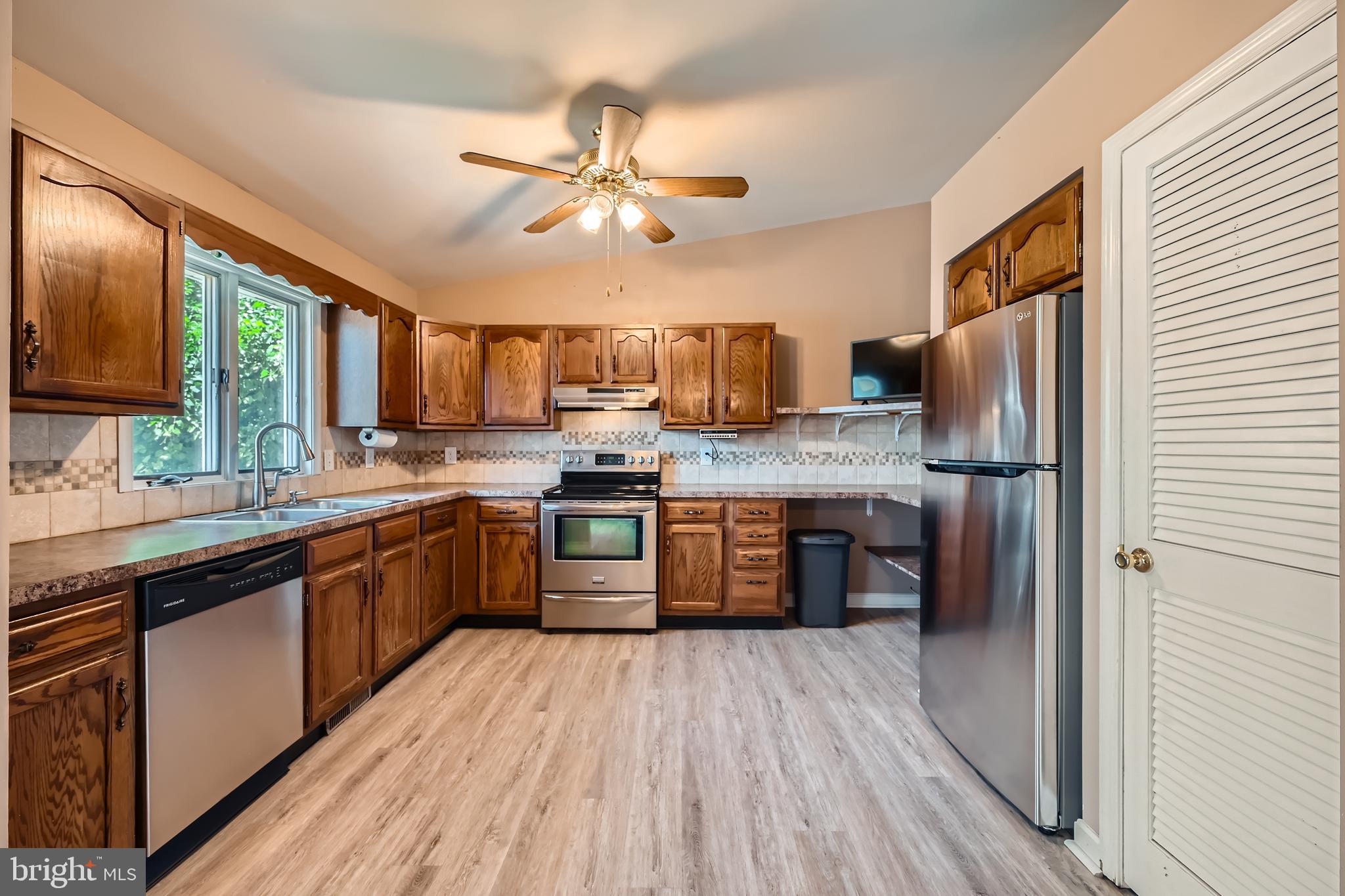 335 Poplar Road Baltimore, MD 21221 - Photo 9 of 34 a kitchen with stainless steel appliances granite countertop a refrigerator a stove top oven a sink dishwasher and wooden cabinets