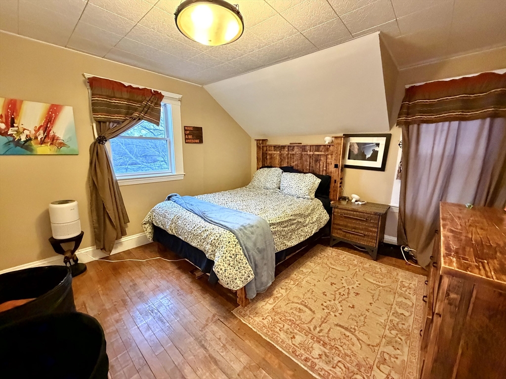 157 Riverview Avenue, Unit FURNISHED Waltham, MA 02453 - Photo 22 of 38 a bedroom with a bed and wooden floor