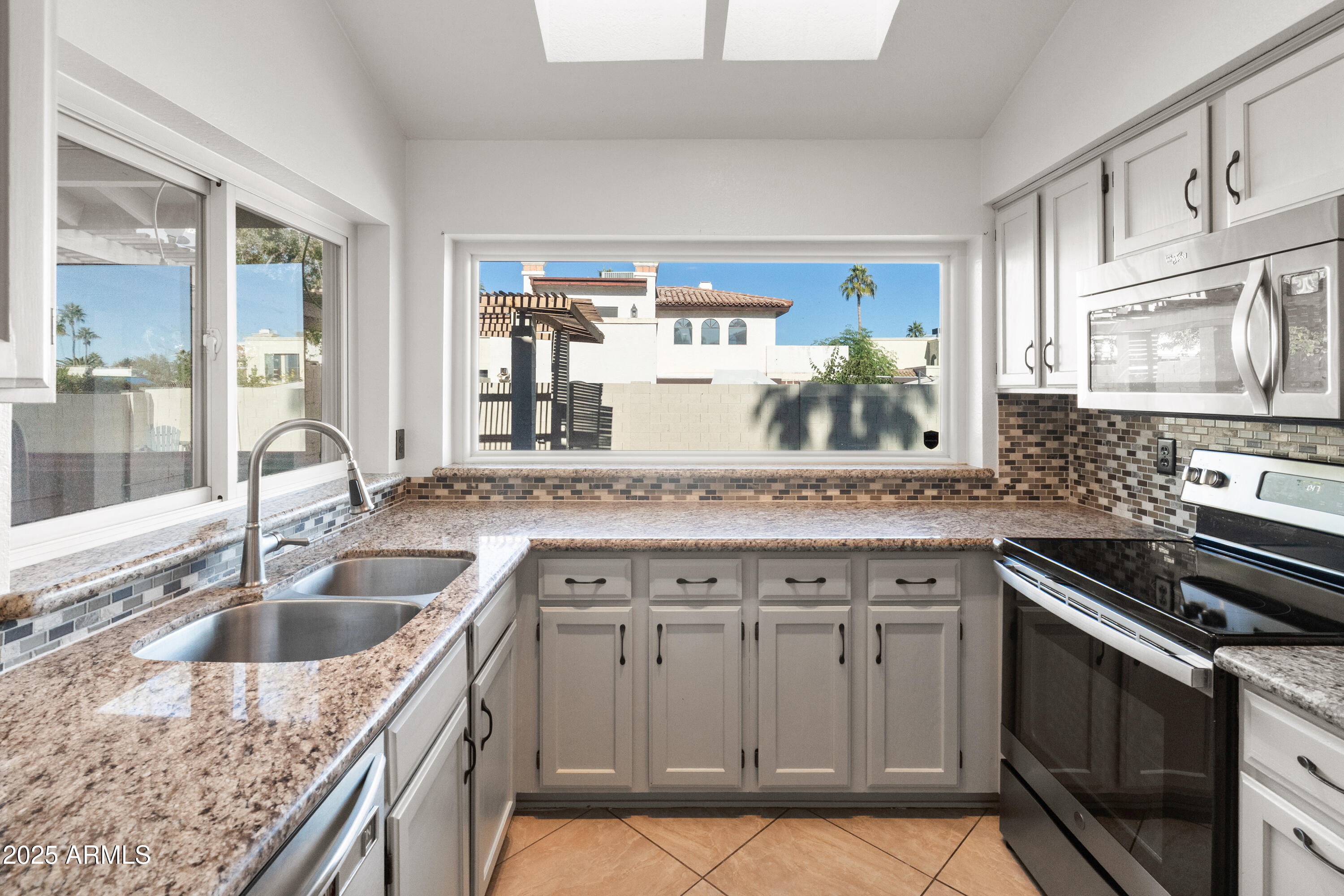 4652 East Piedmont Road Phoenix, AZ 85044 - Photo 10 of 30 a kitchen with granite countertop a sink stove and cabinets