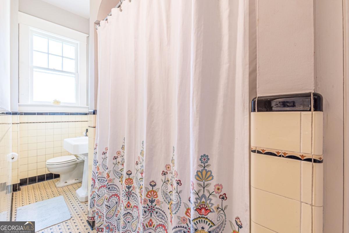 1878 Cambridge Avenue Atlanta, GA 30337 - Photo 50 of 84 a bathroom with a toilet and a shower curtain