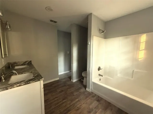 a bathroom with a granite countertop sink a bathtub and a shower
