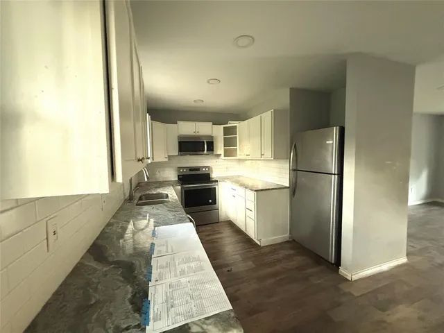 a large kitchen with cabinets and stainless steel appliances