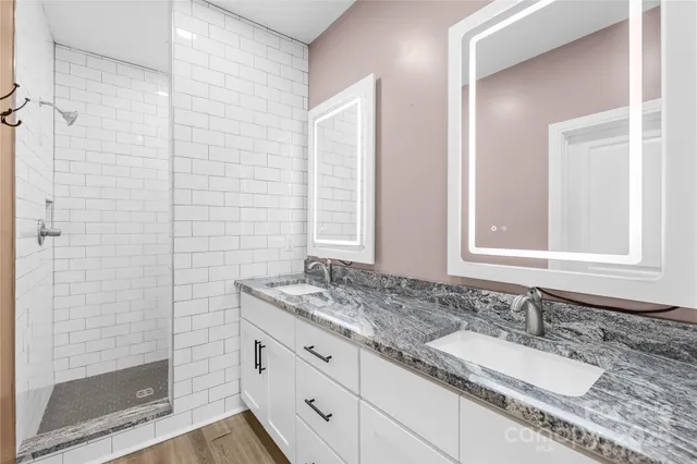 a bathroom with a granite countertop sink and a mirror