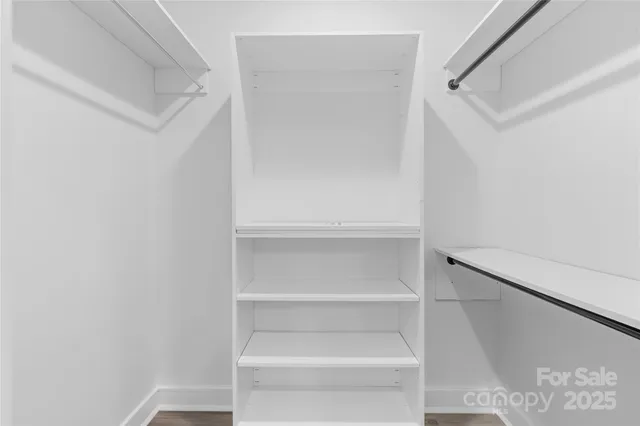 a view of walk in closet with empty racks