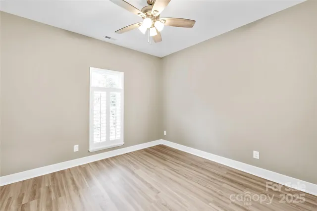 an empty room with a window and wooden floor
