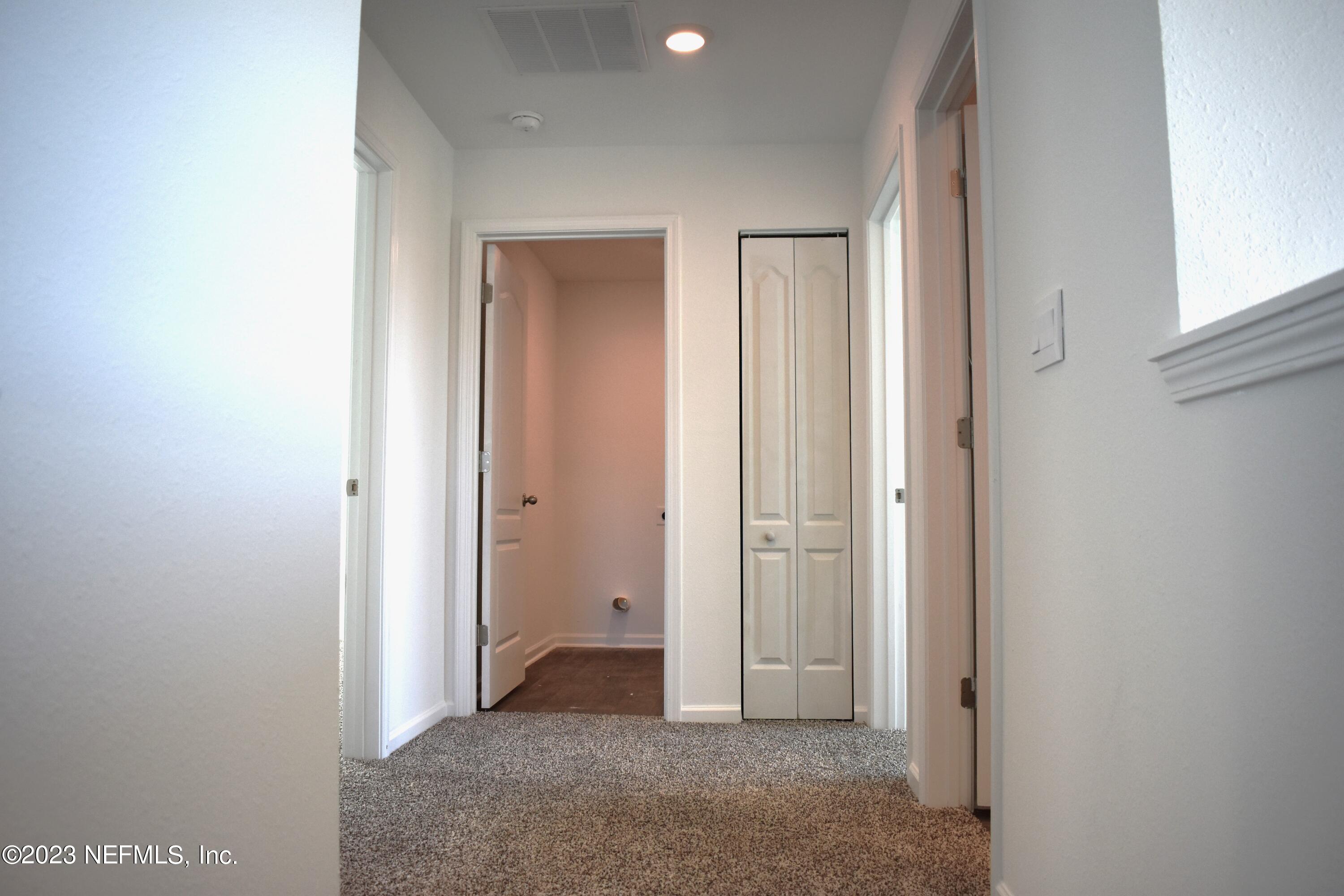 12817 Cacao Tree Trail Jacksonville, FL 32218 - Photo 14 of 41 a view of a hallway with closet and bathroom