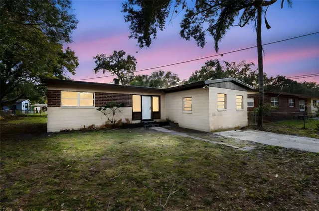 a view of a house with backyard and a tree