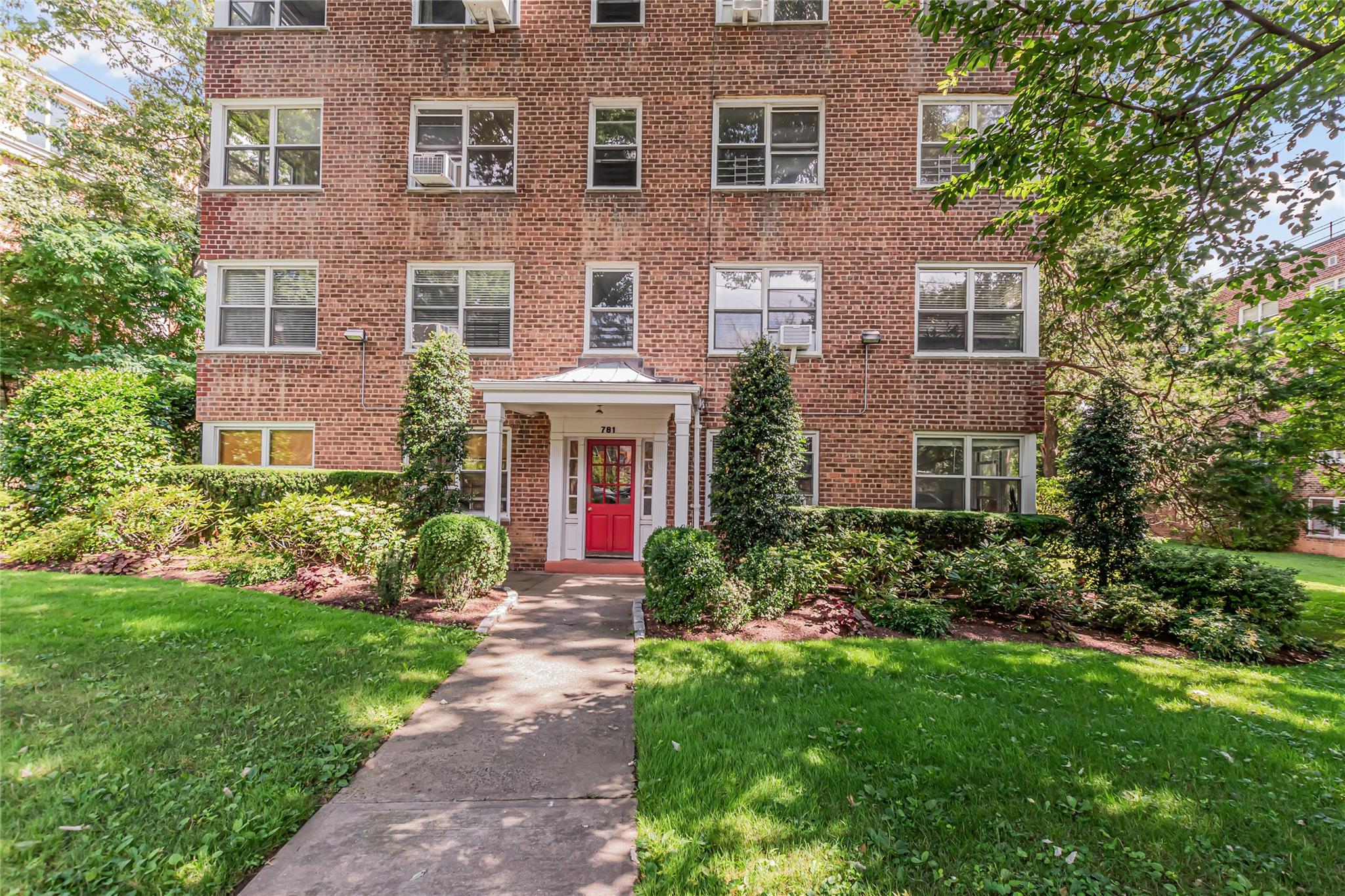781 Palmer Road, Unit 3B Yonkers, NY 10708 - Photo 1 of 1 a front view of a house with garden and trees