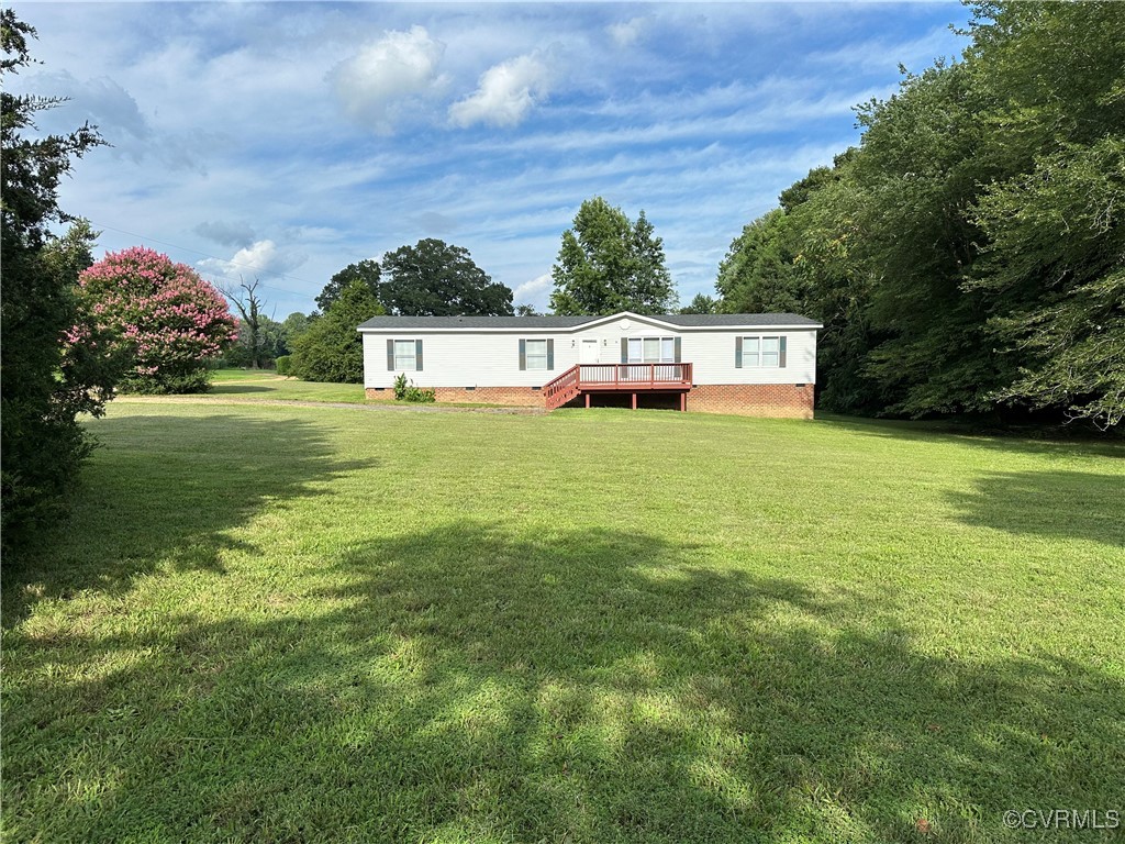Front View of green lawn featuring a wooden deck