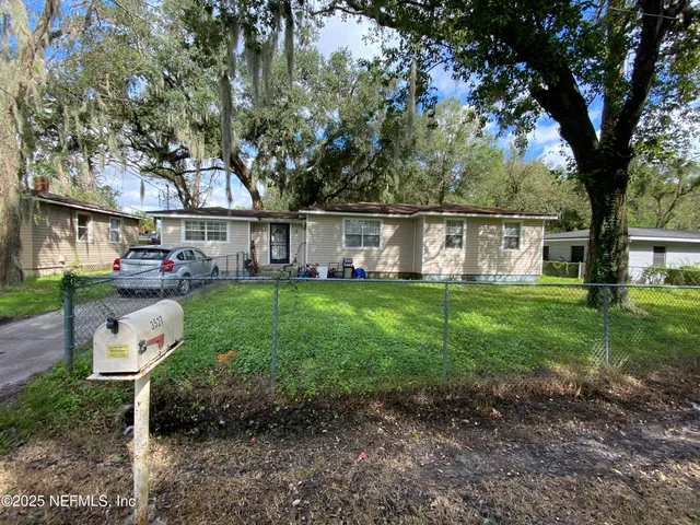 a view of a house with backyard and sitting area