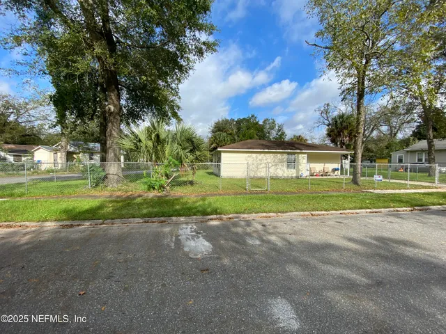 a view of a house with a big yard and large trees