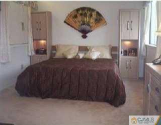 5508 Hana Road Edison, NJ 08817 - Photo 4 of 6 a bedroom with a bed and a painting on the wall
