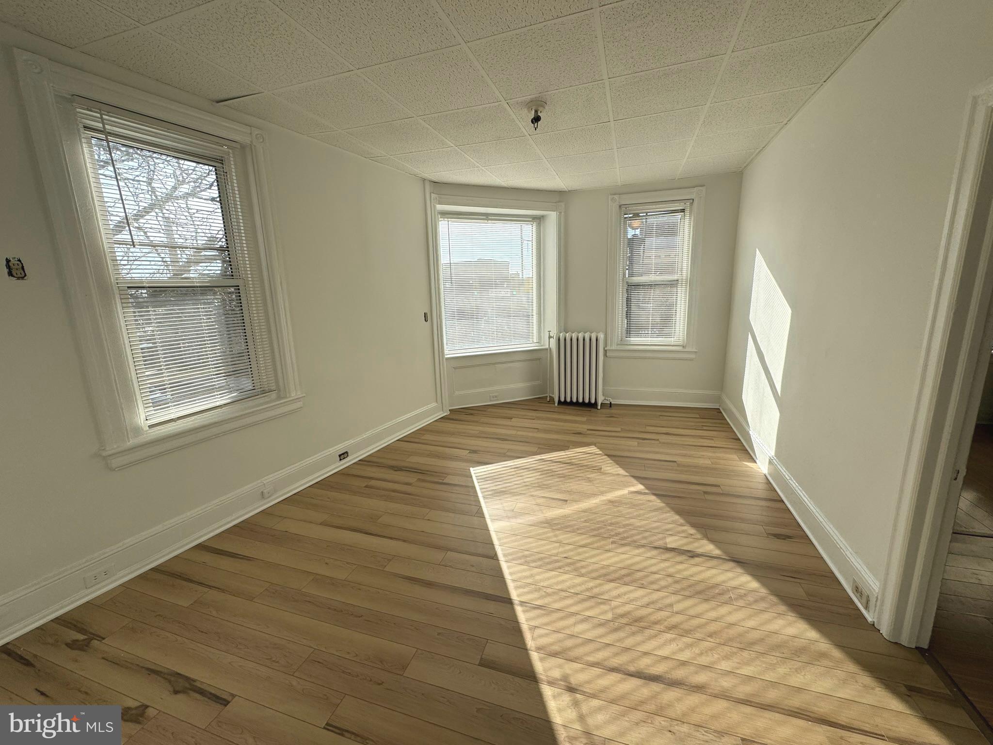 1 North Main Street, Unit 2F Ambler, PA 19002 - Photo 4 of 23 a view of an empty room with wooden floor and a window