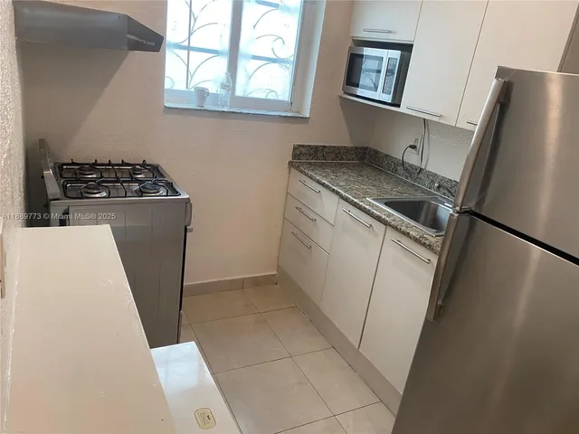 a kitchen with stainless steel appliances a refrigerator sink and stove
