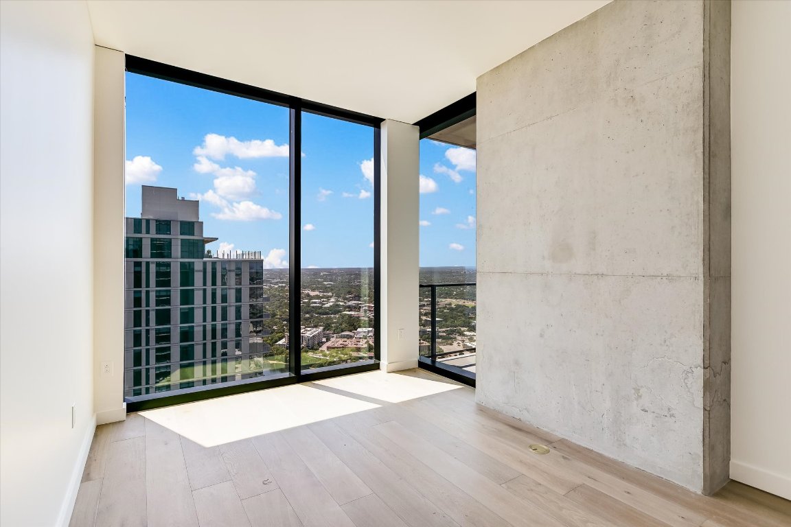 610 Davis Street, Unit 4602 Austin, TX 78701 - Photo 13 of 35 an empty room with wooden floor and windows