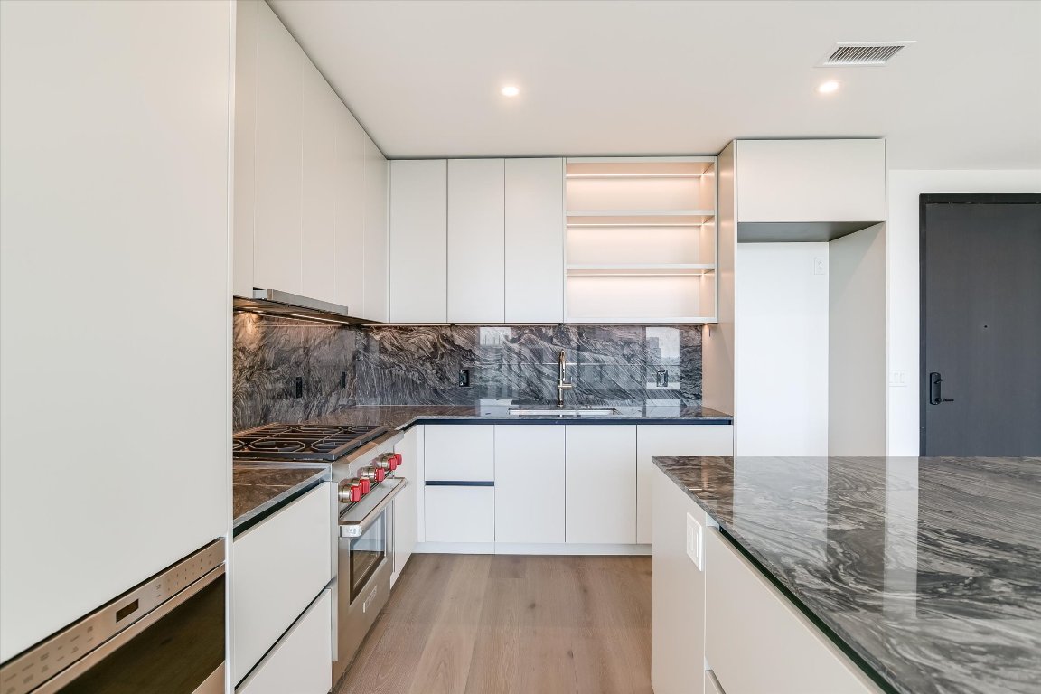 610 Davis Street, Unit 4602 Austin, TX 78701 - Photo 4 of 35 a view of a kitchen with kitchen island a counter top space and stainless steel appliances