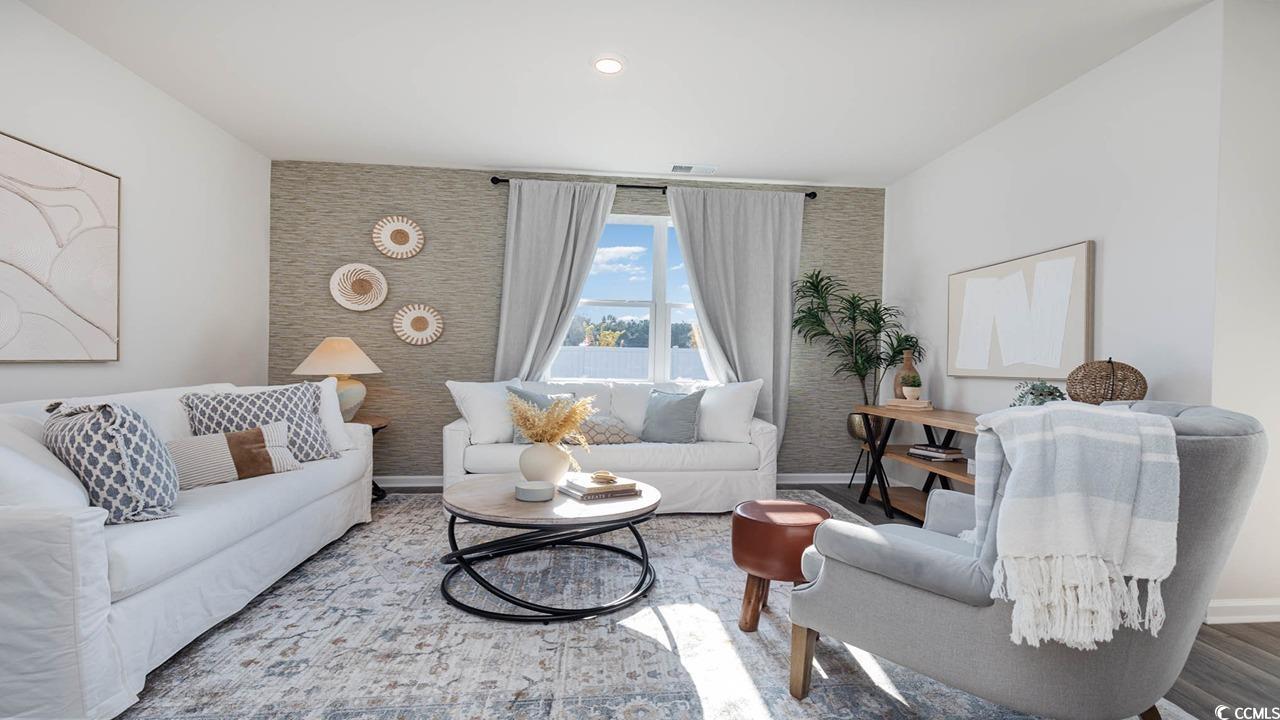 7383 Meadow Walk Loop Loris, SC 29569 - Photo 10 of 29 Living area featuring visible vents, wood finished floors, and baseboards