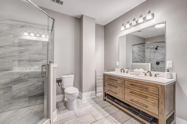 a bathroom with a double vanity sink mirror and toilet