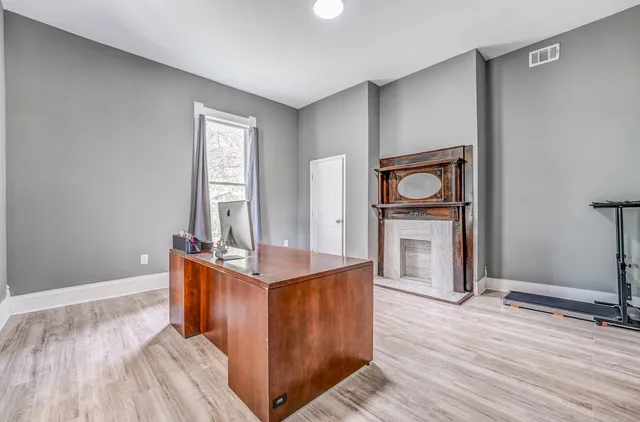 a view of a kitchen with kitchen island wooden floor and electronic appliances