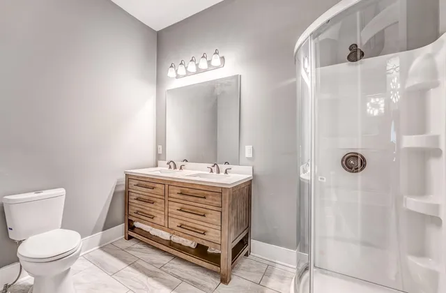 a bathroom with a sink a toilet and shower