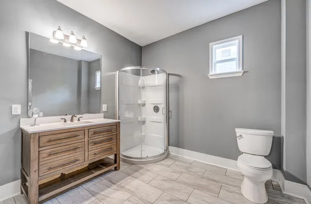 a bathroom with a sink a toilet and shower