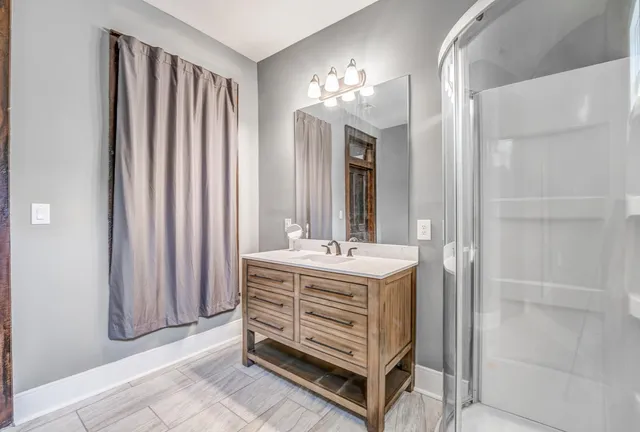 a bathroom with a sink a mirror and a shower