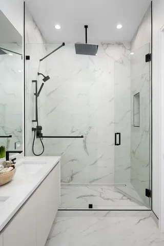 a bathroom with a granite countertop sink a toilet and shower
