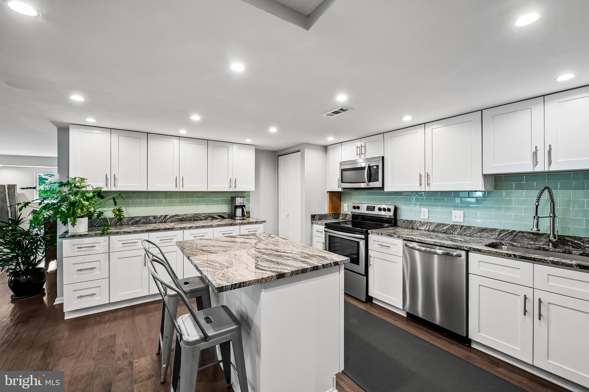 1040 Deer Ridge Drive, Unit 200 Baltimore, MD 21210 - Photo 15 of 38 a kitchen with granite countertop white cabinets and stainless steel appliances