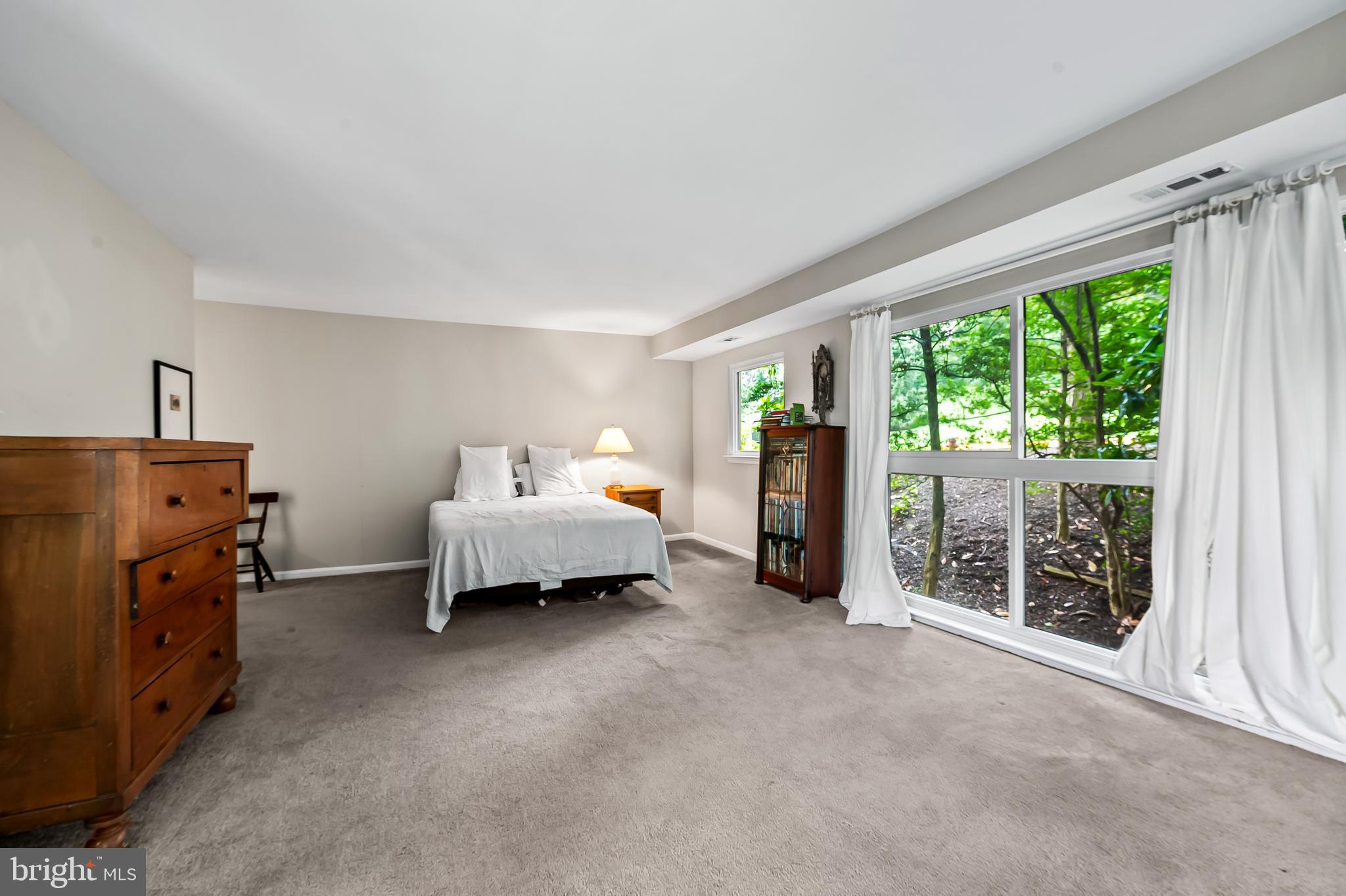 1040 Deer Ridge Drive, Unit 200 Baltimore, MD 21210 - Photo 24 of 38 a spacious bedroom with a bed and large windows