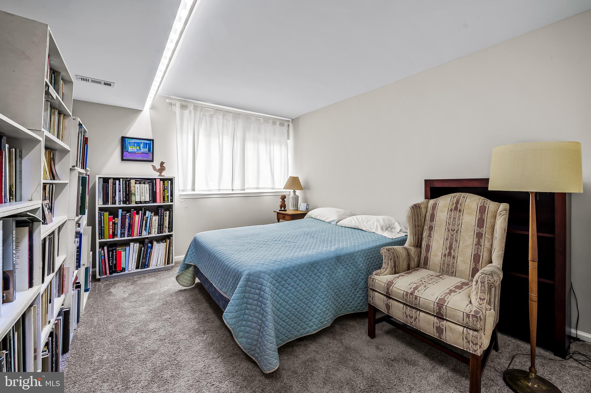 1040 Deer Ridge Drive, Unit 200 Baltimore, MD 21210 - Photo 28 of 38 a bedroom with a bed a book shelf and a window