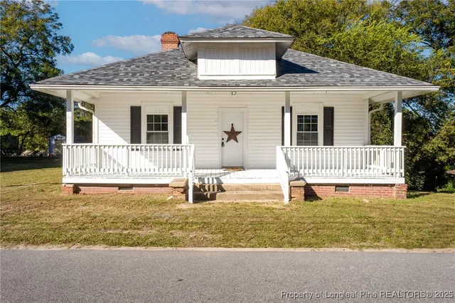 a front view of a house with a yard and porch