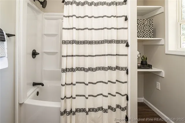a bathroom with a shower curtain and a window