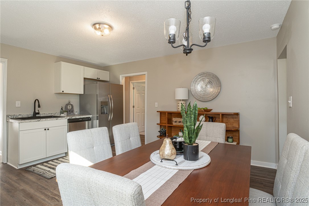 102 North 17th Street Erwin, NC 28339 - Photo 17 of 32 a living room with white couches and kitchen view with wooden floor