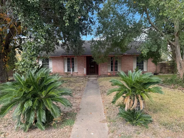 a front view of house with yard and trees around