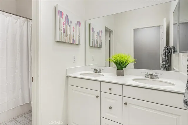 a bathroom with a double vanity sink and a mirror