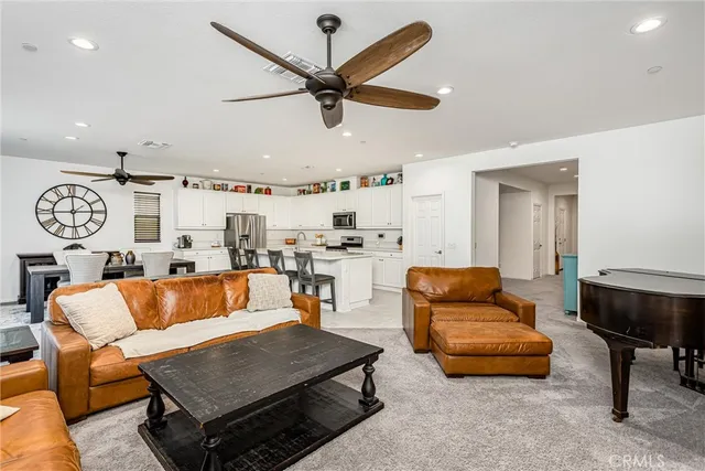 a living room with furniture kitchen view and a window