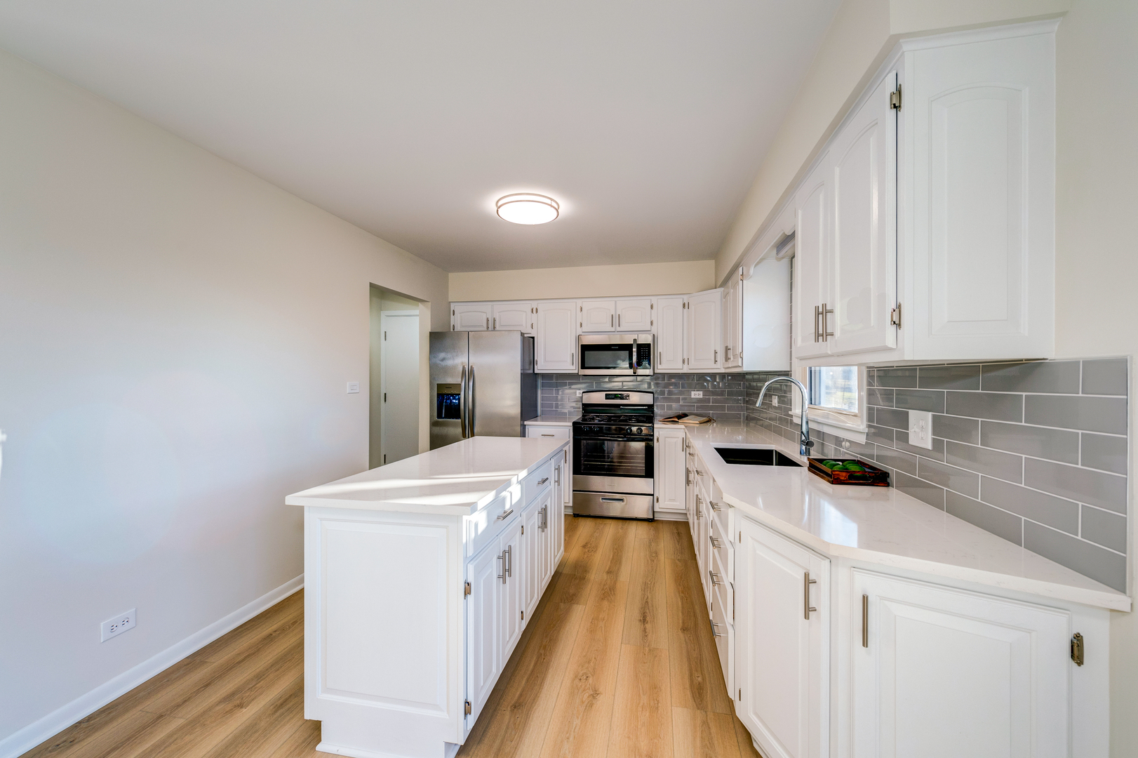 2S746 South Raddant Road Batavia, IL 60510 - Photo 10 of 27 a kitchen with stainless steel appliances a stove a sink a refrigerator white cabinets and wooden floor