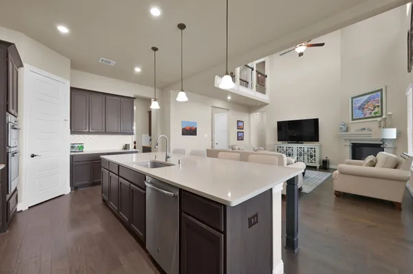 a kitchen with kitchen island granite countertop a center island a wooden floor stainless steel appliances and cabinets