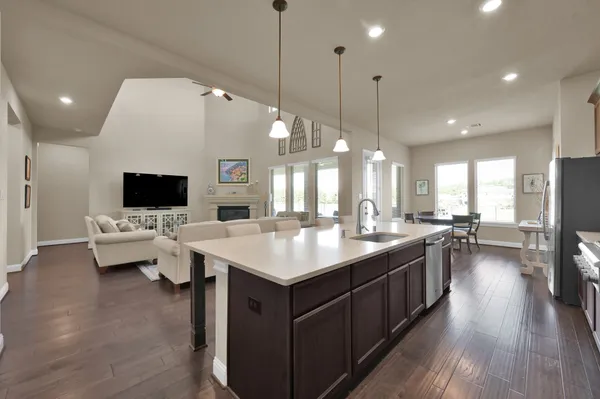 a kitchen with stainless steel appliances wooden floor and dining table