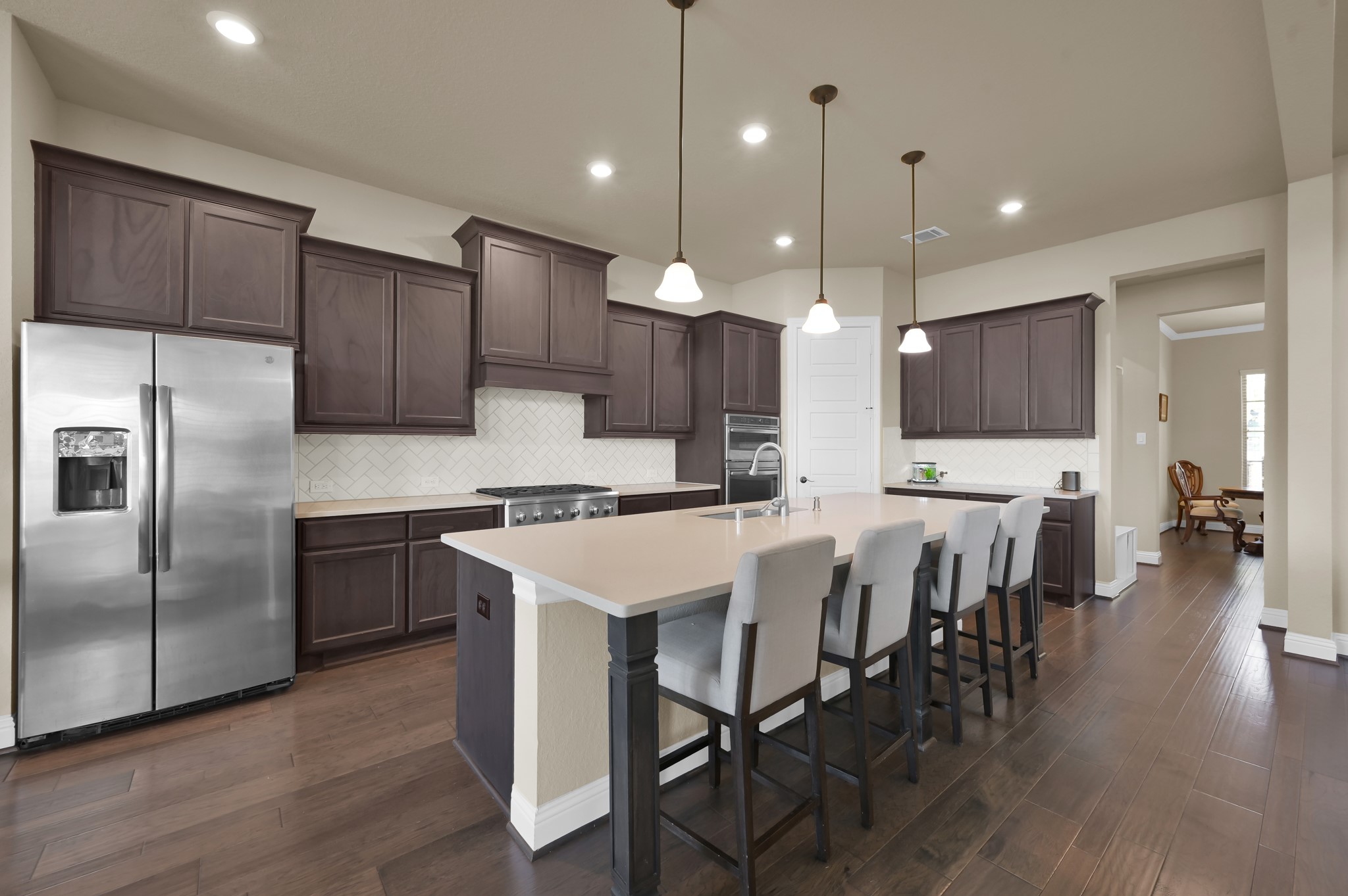 4906 Tres Lagos Drive Spring, TX 77389 - Photo 13 of 32 a kitchen with kitchen island granite countertop a center island a wooden floor stainless steel appliances and cabinets