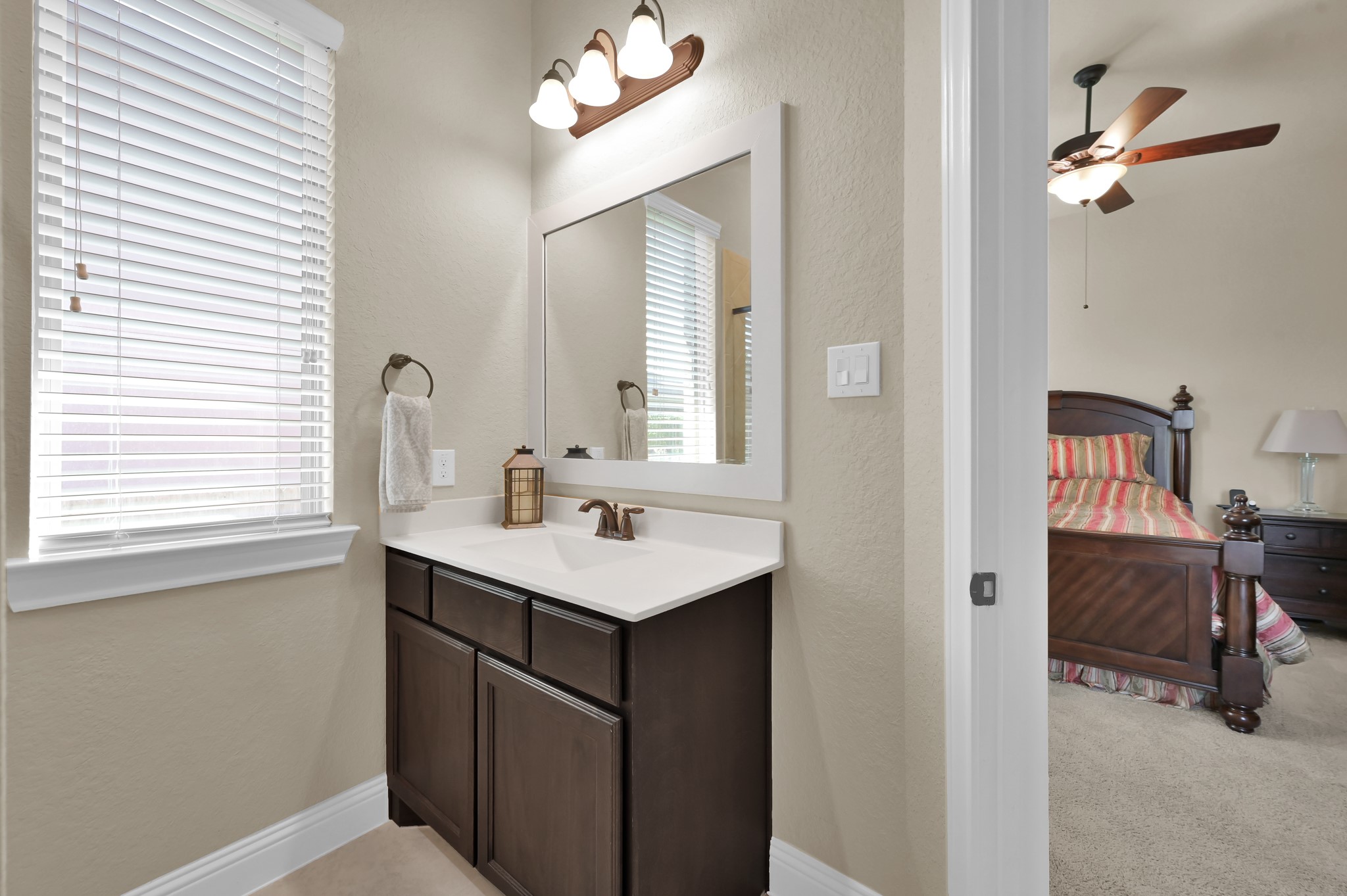 4906 Tres Lagos Drive Spring, TX 77389 - Photo 18 of 32 a en suite bathroom with a sink a mirror and a vanity