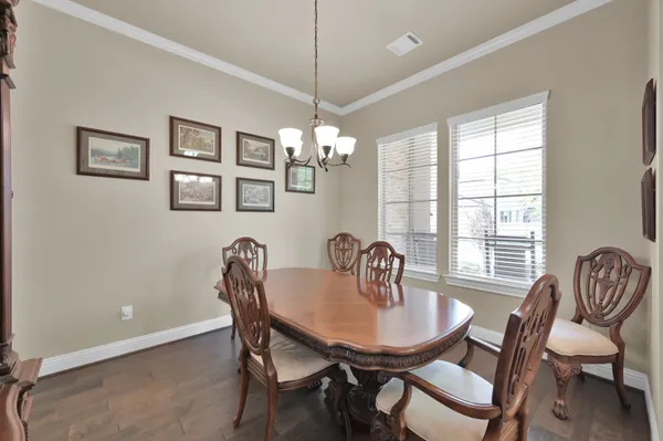 a dining room with furniture a potted plant and a chandelier