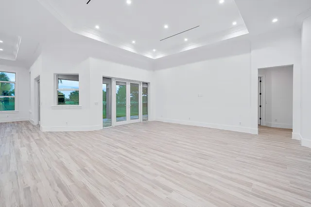 a view of empty room with wooden floor and windows