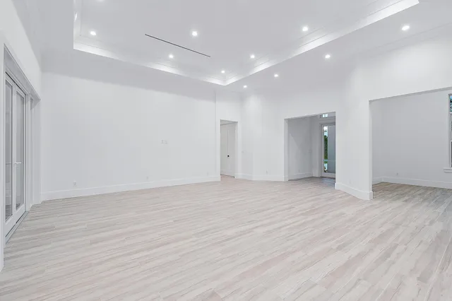 a view of a kitchen with kitchen island stainless steel appliances wooden floor and living room view