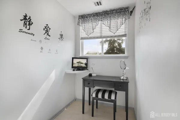 a view of a workspace with furniture and a window